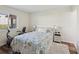 Cozy bedroom with a floral patterned bed, a white nightstand, and a window offering natural light at 7515 Greystone Dr, Hudson, FL 34667