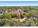 Scenic aerial shot of clubhouse surrounded by lush greenery and mature trees, with a private road at 7515 Greystone Dr, Hudson, FL 34667