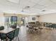 A spacious clubhouse room with tile flooring, tables, chairs, and sliding glass doors at 7515 Greystone Dr, Hudson, FL 34667