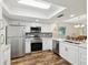 Bright kitchen with stainless steel appliances, white cabinets, and a view into the dining area at 7515 Greystone Dr, Hudson, FL 34667