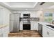 Stylish kitchen featuring stainless steel appliances, white cabinets, and a sleek backsplash at 7515 Greystone Dr, Hudson, FL 34667