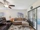 Inviting living room featuring a comfortable sectional sofa, ceiling fan, and sliding glass doors to the sunroom at 7515 Greystone Dr, Hudson, FL 34667