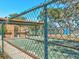 View from behind the fence of the bocce ball court and the covered picnic area with tables and benches at 7515 Greystone Dr, Hudson, FL 34667