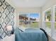 Bright sunroom with a comfortable bed and large windows offering plenty of natural light and views of the backyard at 7515 Greystone Dr, Hudson, FL 34667
