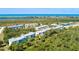 Aerial view of condominiums nestled among trees, with a glimpse of the ocean in the background at 8403 Placida Rd # 205, Placida, FL 33946
