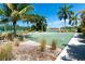 A well-maintained outdoor basketball court surrounded by lush landscaping and clear blue skies at 8403 Placida Rd # 205, Placida, FL 33946