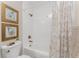 Cozy bathroom with framed art and a shower/tub combination featuring white tile and bronze fixtures at 8403 Placida Rd # 205, Placida, FL 33946