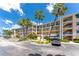 Condominium exterior with balconies, lush landscaping, and ample parking at 8403 Placida Rd # 205, Placida, FL 33946