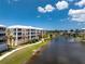 View of the building complex situated next to a pond with a fountain on a sunny day at 8403 Placida Rd # 205, Placida, FL 33946