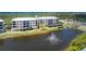 Scenic view of the building complex with a beautiful pond featuring a fountain in front at 8403 Placida Rd # 205, Placida, FL 33946
