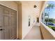 Hallway view featuring unit entry door, lighting, and exterior views of landscaping at 8403 Placida Rd # 205, Placida, FL 33946