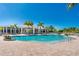 Inviting community pool with lounge area and pavilion set against a clear blue sky and lush tropical plants at 8403 Placida Rd # 205, Placida, FL 33946