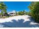 Beach volleyball court with net, lush greenery and parked cars under clear skies in a sunny community at 8403 Placida Rd # 205, Placida, FL 33946