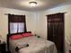 Bedroom featuring a comfortable queen bed with brown curtains for privacy at 8629 Aero Ave, North Port, FL 34287