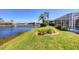 Waterfront backyard with meticulously kept lawn and mature landscaping offering tranquil outdoor living at 863 Macaw Cir, Venice, FL 34285