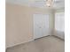 Bright bedroom with neutral carpet, paint and white closet doors at 863 Macaw Cir, Venice, FL 34285