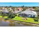 Beautiful exterior view of a home with a screened lanai and well-maintained landscaping overlooking the waterfront at 863 Macaw Cir, Venice, FL 34285