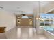 Bright living area with tiled floors, fan, pool and lake views through large windows, and neutral wall color at 863 Macaw Cir, Venice, FL 34285