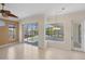 Bright living area with pool and lake views, featuring tile flooring, fan, and sliders to the outdoor area at 863 Macaw Cir, Venice, FL 34285