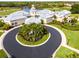 Aerial view of clubhouse featuring the signature flagpole, circular drive, and surrounding golf course at 867 Macaw Cir, Venice, FL 34285