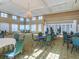Spacious ballroom filled with tables and chairs, featuring a chandelier and several windows at 867 Macaw Cir, Venice, FL 34285