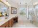 Bathroom featuring a soaking tub, glass-enclosed shower, and double vanity sinks at 867 Macaw Cir, Venice, FL 34285