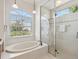 Bright bathroom with soaking tub and a glass-enclosed shower at 867 Macaw Cir, Venice, FL 34285