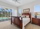 Bedroom with an elegant wooden bed frame and view of the pool area at 867 Macaw Cir, Venice, FL 34285