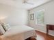 Well-lit bedroom featuring wood floors, ceiling fan, neutral colors, and a bright window at 867 Macaw Cir, Venice, FL 34285