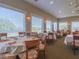 Elegant dining room with large windows, multiple tables and chairs for residents and guests at 867 Macaw Cir, Venice, FL 34285