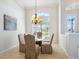 Bright dining room featuring a glass table, six upholstered chairs, and a decorative chandelier at 867 Macaw Cir, Venice, FL 34285