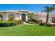 Charming single-story home featuring a well-manicured lawn, lush landscaping, and a welcoming front entrance at 867 Macaw Cir, Venice, FL 34285
