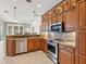 Kitchen showcasing stainless steel appliances, granite countertops, and wood cabinetry at 867 Macaw Cir, Venice, FL 34285
