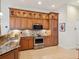 Kitchen showcasing stainless steel appliances, granite countertops, and wood cabinetry at 867 Macaw Cir, Venice, FL 34285