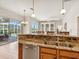 Open kitchen with granite countertops and stainless steel appliances overlooking the outdoor pool area at 867 Macaw Cir, Venice, FL 34285