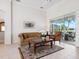 Comfortable living room with a ceiling fan, large windows, and sliding glass doors leading to the screened-in porch at 867 Macaw Cir, Venice, FL 34285