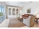 Living room with a ceiling fan, built-in shelving, tile flooring, and a sliding glass door leading to the lanai at 867 Macaw Cir, Venice, FL 34285