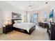 Bright main bedroom with tray ceilings, a ceiling fan, and a view of the pool at 867 Macaw Cir, Venice, FL 34285
