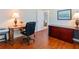 Well-lit home office area with wood floors and a view into the home at 867 Macaw Cir, Venice, FL 34285
