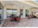 Covered patio featuring brick flooring, ceiling fan and comfortable seating with outdoor dining set at 867 Macaw Cir, Venice, FL 34285