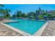 Sparkling community pool with clear water and various seating and lush landscaping at 867 Macaw Cir, Venice, FL 34285
