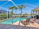 Inviting screened pool with brick patio, lounge chairs, and lovely water view at 867 Macaw Cir, Venice, FL 34285