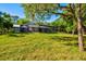 Expansive backyard with lush green grass and a screened in pool area, perfect for outdoor activities at 8902 Tropicaire Blvd, North Port, FL 34291