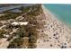 Stunning aerial view highlighting direct beach access near a building and a path to the sandy shore at 9312 Coachman Dr, Venice, FL 34293
