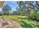 Expansive backyard with lush green grass and mature trees, providing a private and serene outdoor space at 9312 Coachman Dr, Venice, FL 34293