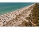 Picturesque beach aerial featuring sunbathers, umbrellas, and clear turquoise water in a relaxing coastal setting at 9312 Coachman Dr, Venice, FL 34293