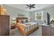 Comfortable bedroom featuring a wicker bed frame, soft bedding, and a ceiling fan for added comfort at 9312 Coachman Dr, Venice, FL 34293