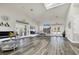 Spacious common room with wood floors, large windows, comfortable seating, and a soaring ceiling with ample natural light at 9312 Coachman Dr, Venice, FL 34293
