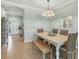 Bright dining room with tile floors and a bench, wicker chairs and white framed mirror wall decor at 9312 Coachman Dr, Venice, FL 34293
