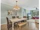 Inviting dining area with a chandelier, a decorative mirror, and wicker chairs surrounding a wooden table at 9312 Coachman Dr, Venice, FL 34293